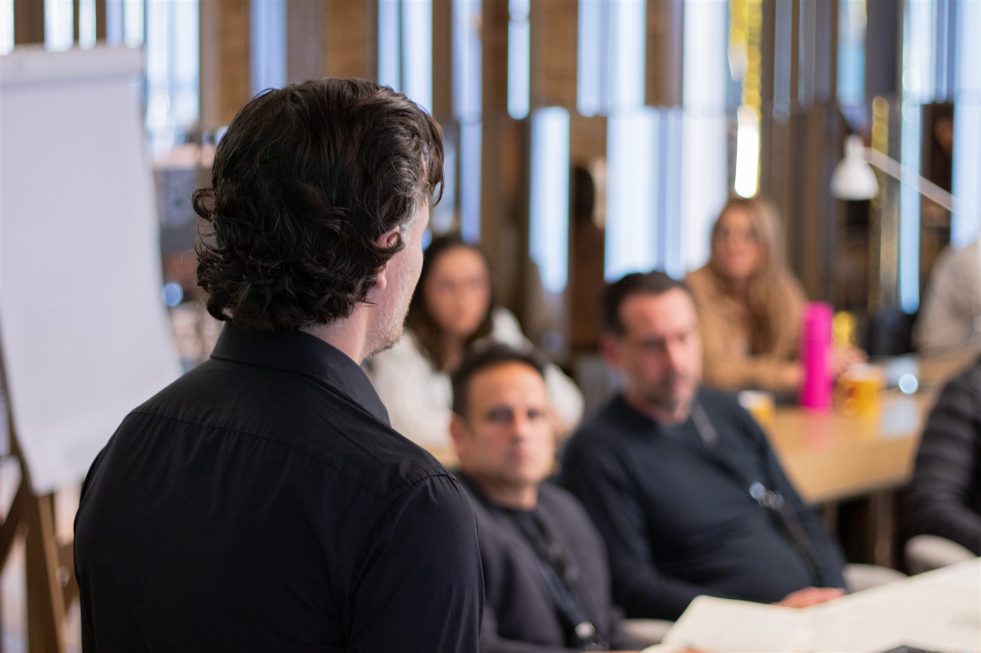Rick conduzindo uma sessão do Sprint, de costas para a turma, no flip chart